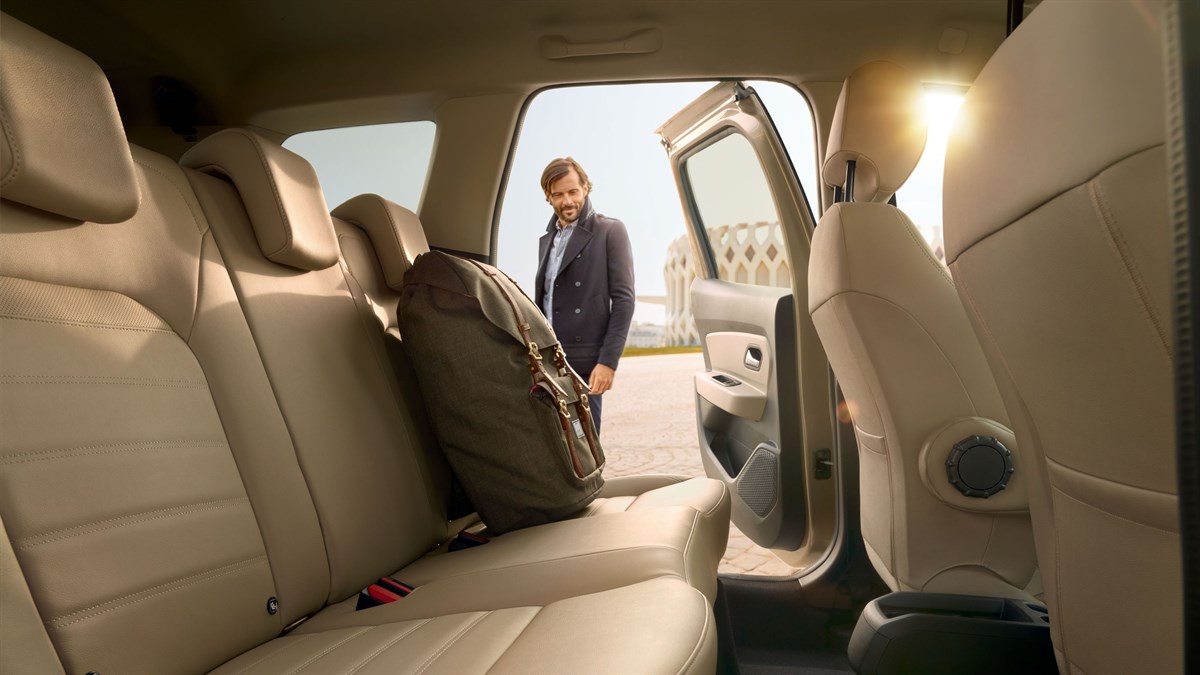 A man looking at his bag kept at the back seat of the All-New Renault Duster