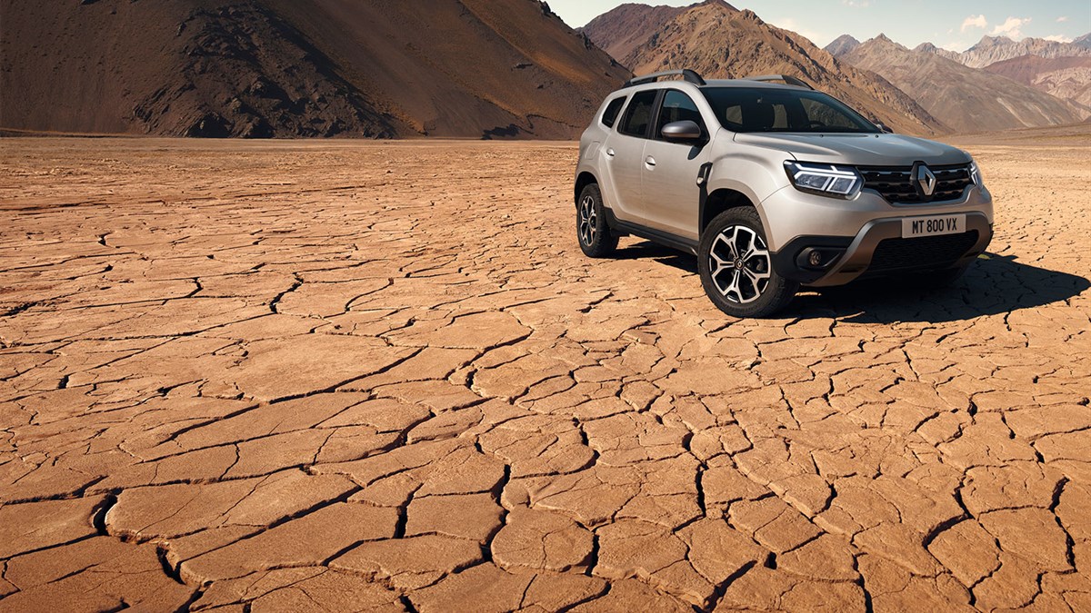 A family having conversation standing next to their parked All-New Renault Duster