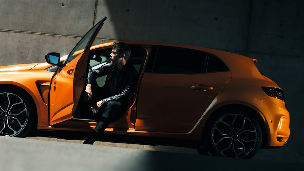 A man sitting while keeping his Renault MEGANE R.S. front door open