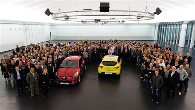 A well-dressed group of people surrounded two cars standing in a 'U' shape