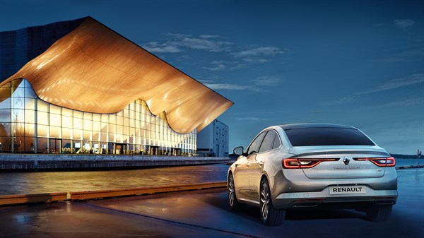 A back view of the Renault car moving towards a luxurious building