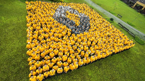 Large crowd people forming Renault symbol taken from a topside view