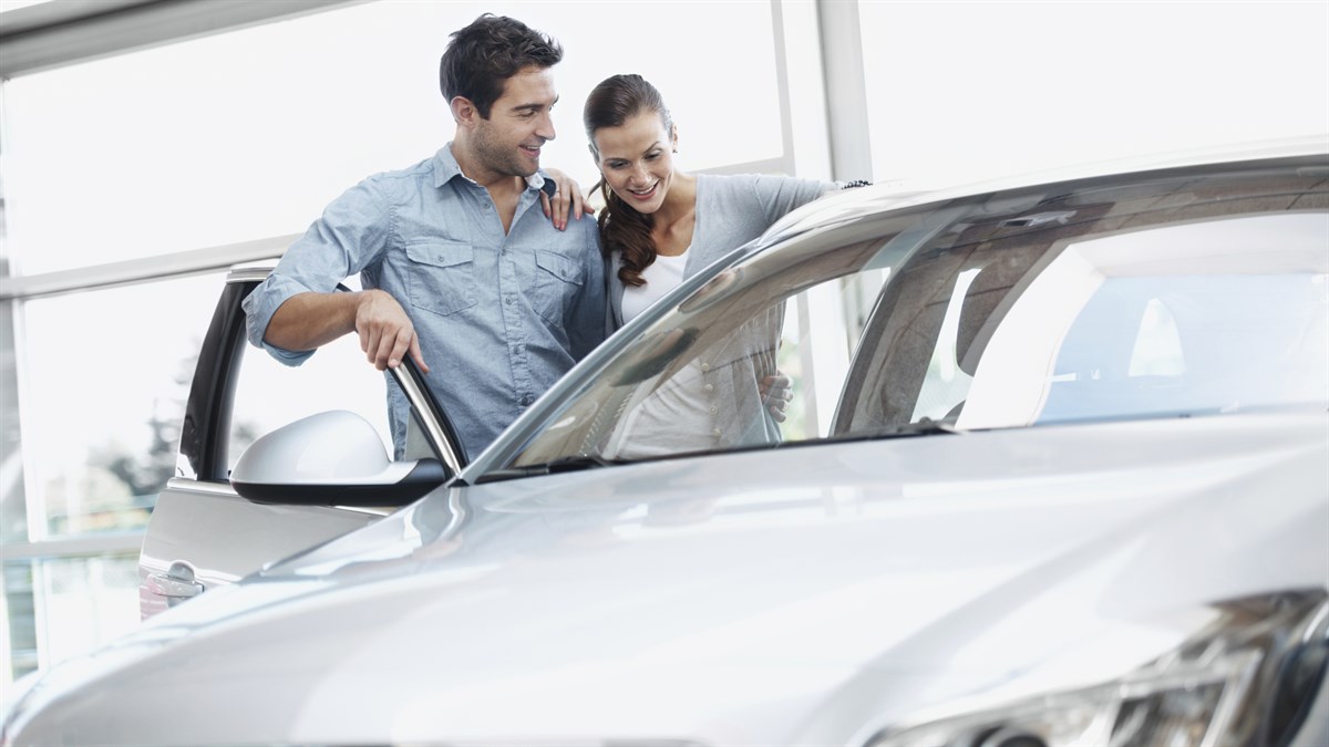 Happy couple looking at the Renault car